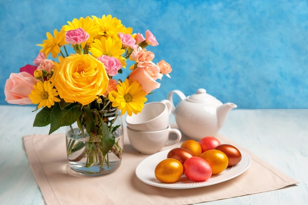 Regolazione della tavola di Pasqua con uova di Pasqua e fiori primaverili. Buona Pasqua. Sfondo di Pasqua di congratulazioni.
