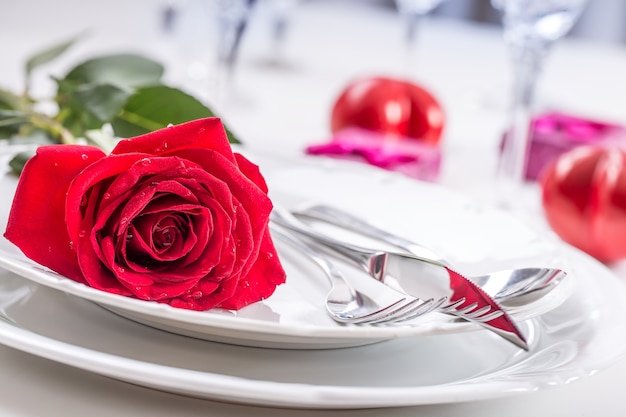 Regolazione della tavola per San Valentino o il giorno del matrimonio con rose rosse Regolazione romantica della tavola per due