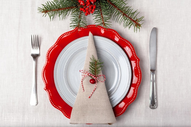 Regolazione semplice della tavola di piatti rossi e grigi su una vista dall'alto di una tovaglia bianca. Foto di alta qualità