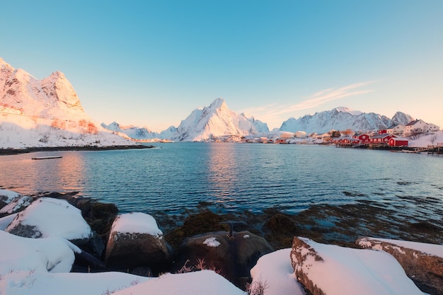 Reine città con villaggio di pescatori e montagna innevata al mattino alle isole Lofoten Norvegia