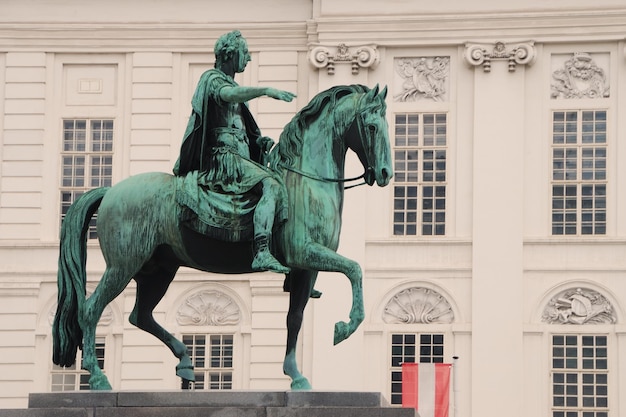 Reiter denkmal auf platz mit antikem haus im hintergrund