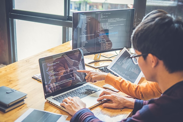Photo rekan bisnis berdiskusi menggunakan laptop di kantor