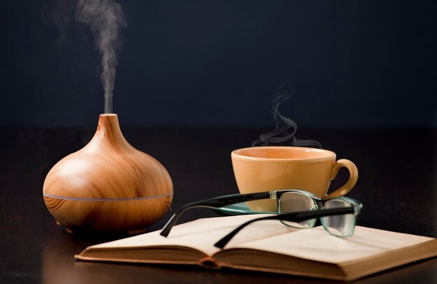 Relax a casa con diffusore di olio aromaterapico tazza da tè gialla libro occhiali da lettura Aroma esse