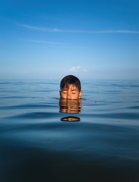 Relax e stile di vita sano. L'adolescente del ragazzo si bagna nel mare.