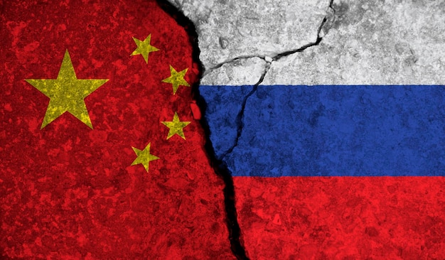 Relazione politica tra Cina e russia bandiere nazionali su sfondo di cemento incrinato