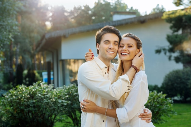 Relazioni d'amore. Gioiosa bella coppia felice che ti sorride mentre si abbracciano