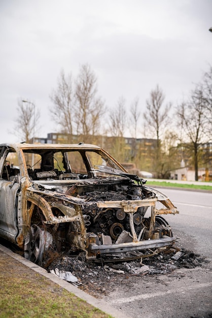 Relitto di un'auto bruciata sul ciglio della strada