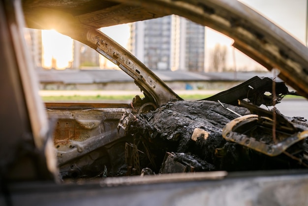 Relitto di un'auto bruciata sul ciglio della strada