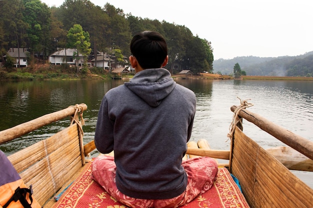 Rematore tailandese waterman che rema zattere di bambù nel lago Pang Ung per i viaggiatori di servizio che le persone viaggiano visitano Pang Oung o la Svizzera del tailandese nell'autentico villaggio cinese Ban Rak Thai a Mae Hong Son Thailandia