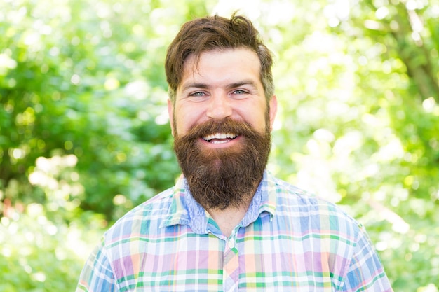 Rendere la felicità possibile Felice hipster con la faccia sorridente sul paesaggio estivo Uomo barbuto con barba lunga e grande sorriso che brilla di felicità in una giornata di sole La felicità è una scelta Concetto di felicità