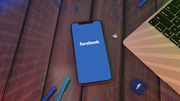 Rendering 3D di uno smartphone che mostra il logo dell'app facebook su un desktop in legno