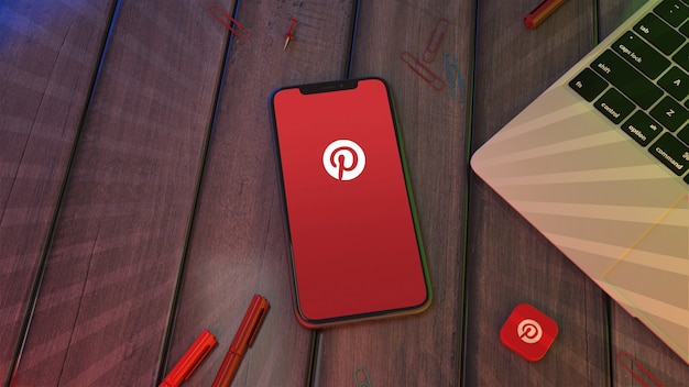 Rendering 3D di uno smartphone con il logo dell'app Pinterest su un desktop in legno