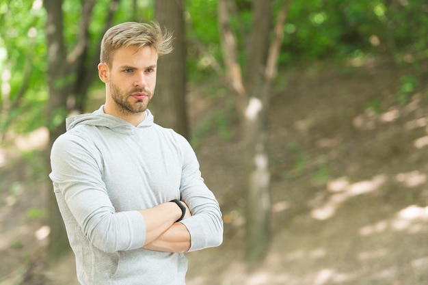 Renditi orgoglioso. Obiettivo sportivo e successo. Completamente pronto. Sfida sportiva. Fiducioso e fisicamente forte. Atleta all'aperto. Fondo della natura del parco dell'uomo bello. Allenamento sportivo e allenamento.