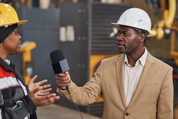 Reporter che intervista il lavoratore nello stabilimento