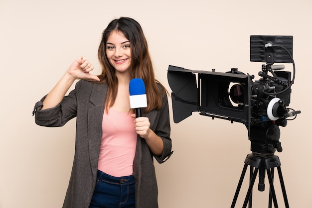 Reporter donna in possesso di un microfono e riportando notizie orgogliose e soddisfatte di sé