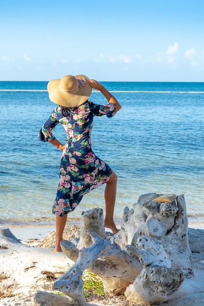 Repubblica Dominicana di Punta Cana una ragazza con un cappello sull'oceano con acqua turchese e palme