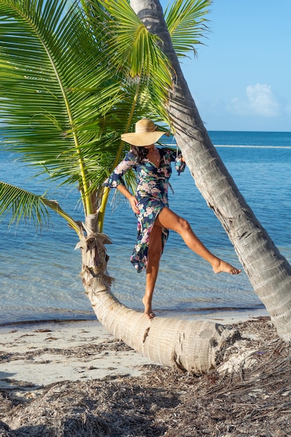 Repubblica Dominicana di Punta Cana una ragazza con un cappello sull'oceano con acqua turchese e palme