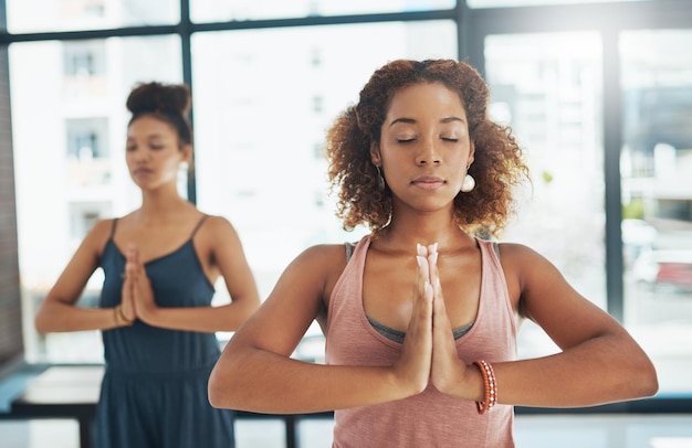 Respira e rilascia tutto ciò che non ti merita Inquadratura di due persone che fanno yoga insieme in uno studio