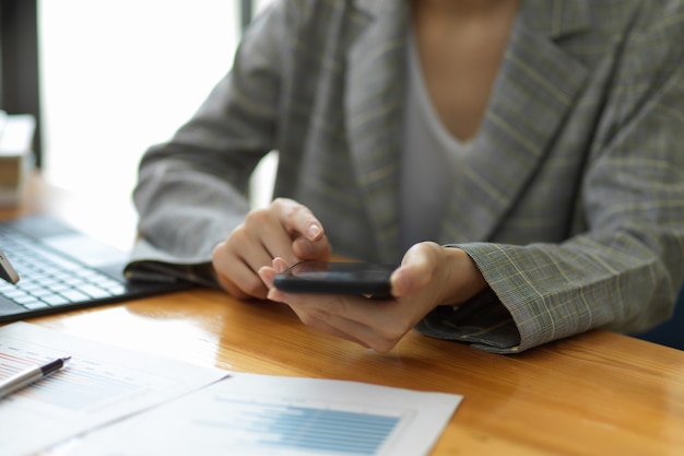 Responsabile professionale della donna di affari che lavora al telefono cellulare nell'area di lavoro dell'ufficio