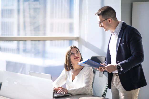 Responsabile uomo e analista di dati donna che lavorano insieme in un ufficio moderno