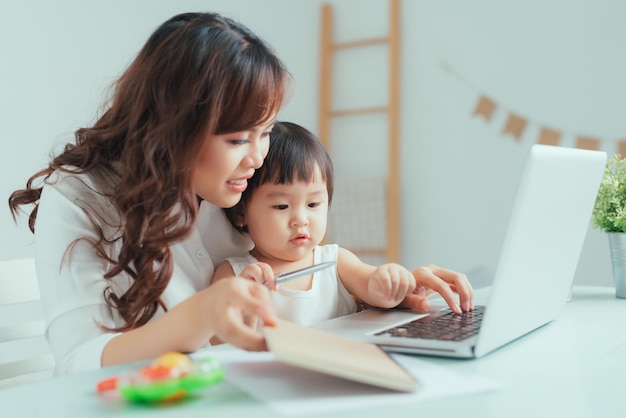 Resta a casa mamma che lavora da remoto sul laptop mentre si prende cura del suo bambino