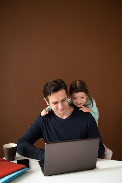 Resta a casa papà che lavora al laptop con una piccola figlia carina