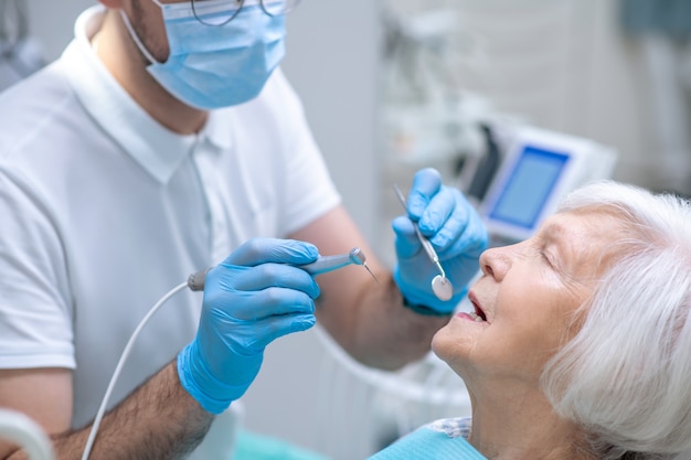 Restauro dei denti. Dentista che ripristina i denti alla paziente anziana