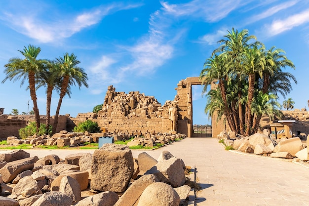 Resti del tempio di Karnak con palme e pietre Luxor Egitto