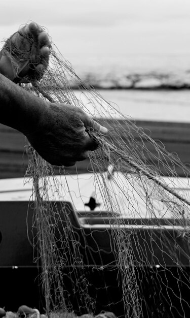 reti alleate con palangari nelle mani di un pescatore, dispone e prepara il materiale per lavorare in mare