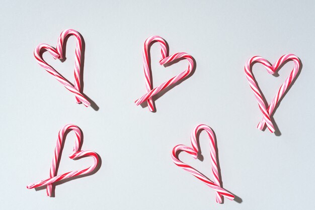 Reticolo di natale del bastoncino di zucchero con forma del cuore su fondo bianco