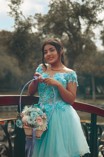 Retrato de una linda chica con vestido azul celebrando sus 15
