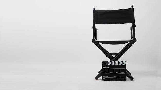 Retro della sedia da regista nera e del ciak. È utilizzato nella produzione di video o nell'industria cinematografica e cinematografica su sfondo bianco