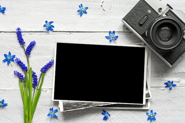 Retro macchina fotografica d'annata, cornice in bianco e fiori blu della molla