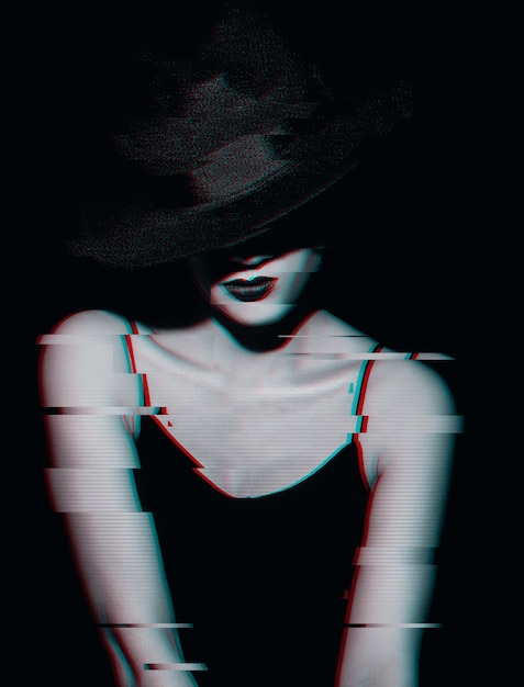 Retro ritratto di una donna in un vestito e un cappello classico su uno sfondo scuro