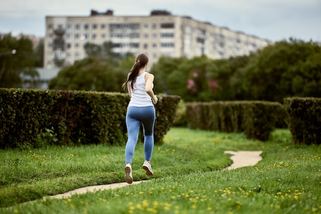 Retrovisione del corridore della donna nel parco della città