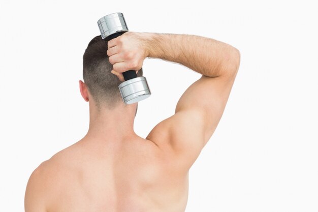 Retrovisione dell&#39;uomo che si esercita con il dumbbell