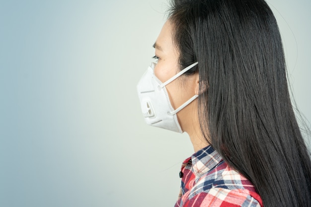 Retrovisione della donna nella maschera a causa dell'inquinamento atmosferico e dell'epidemia in città. Protezione da virus, infezione, gas di scarico ed emissioni industriali