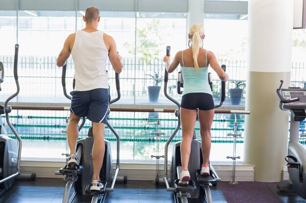 Retrovisione delle coppie che lavorano agli x-trainers alla palestra