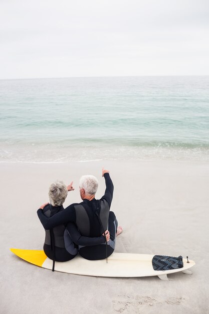 Retrovisione delle coppie che si siedono sul surf