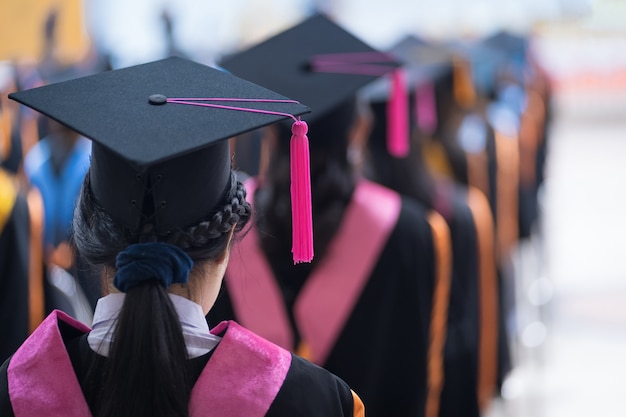 Retrovisore dei laureati in fila per il premio di laurea nella cerimonia di laurea universitaria. I laureati si stanno radunando alla cerimonia di laurea. Folla dei laureati.