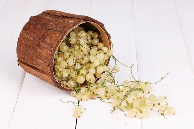 Ribes bianco in tazza di legno su sfondo di legno