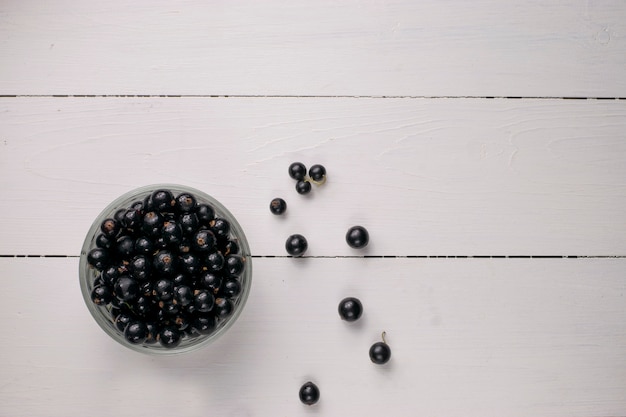 Ribes nero sul tavolo di legno con rametto di foglie