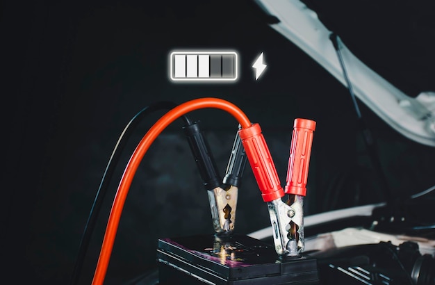 Ricarica della batteria dell'auto e un'icona di ricarica a bagliore nel garage di riparazione auto