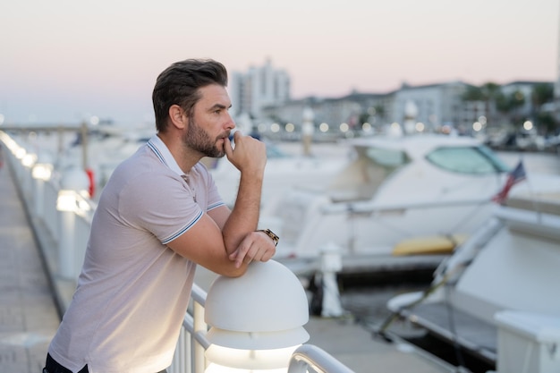 Ricco uomo d'affari che sogna e pensa vicino allo yacht uomo sexy in abiti casual in posa sullo stree