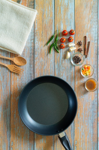 Ricerca per immagine Padella in ghisa e altri utensili da cucina su uno sfondo invecchiato marrone scuro