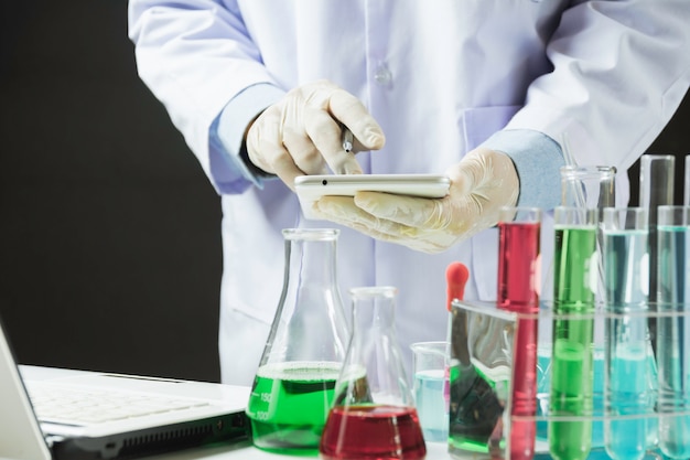 Ricercatore con provette chimiche di vetro da laboratorio con liquido