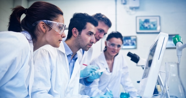 Ricercatori seri che guardano lo schermo del computer in laboratorio