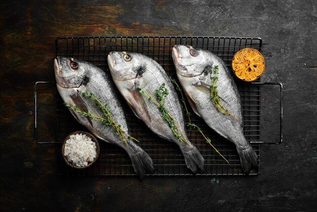 Ricetta del pesce crudo Pesce Dorado con spezie limone e timo Vista dall'alto Spazio per la copia gratuito Su uno sfondo di pietra nera