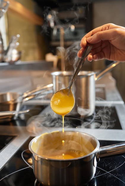 Ricetta della zuppa di zucca La mano dello chef mette gli ingredienti nella pentola e cuoce tutto per accompagnare la zuppa