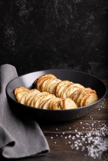 Ricetta di patate al forno, su un tavolo di legno, verticale